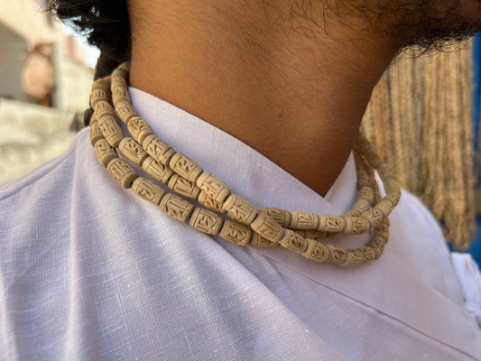 Man wearing a three-round Radha name carved tulsi kanthi mala