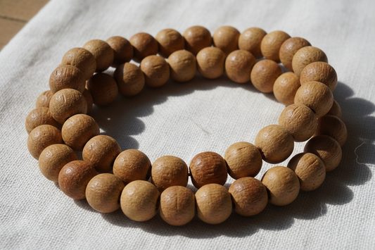 Close-up of round brown wooden prayer beads laid on white cloth